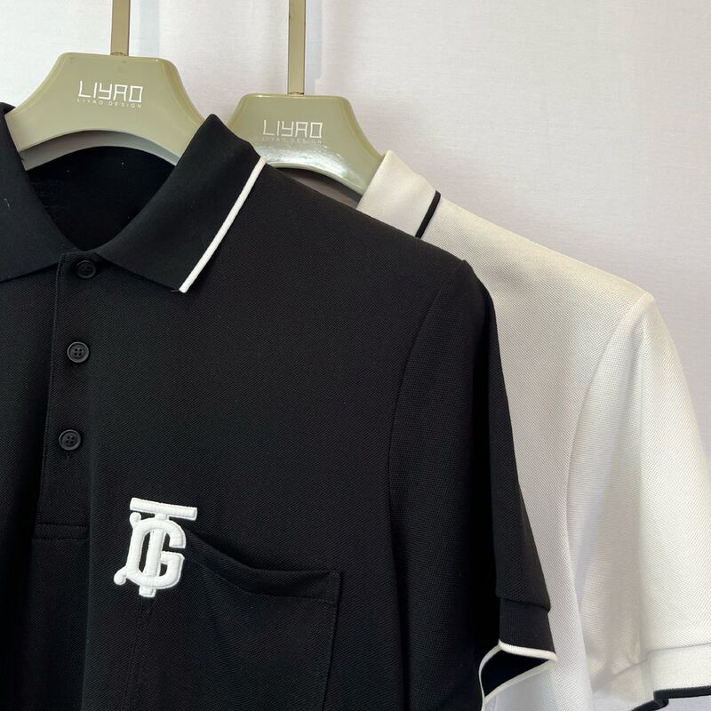 Logo maschile - Polo ricamato. Nero con tasche al petto bianche e monogrammi